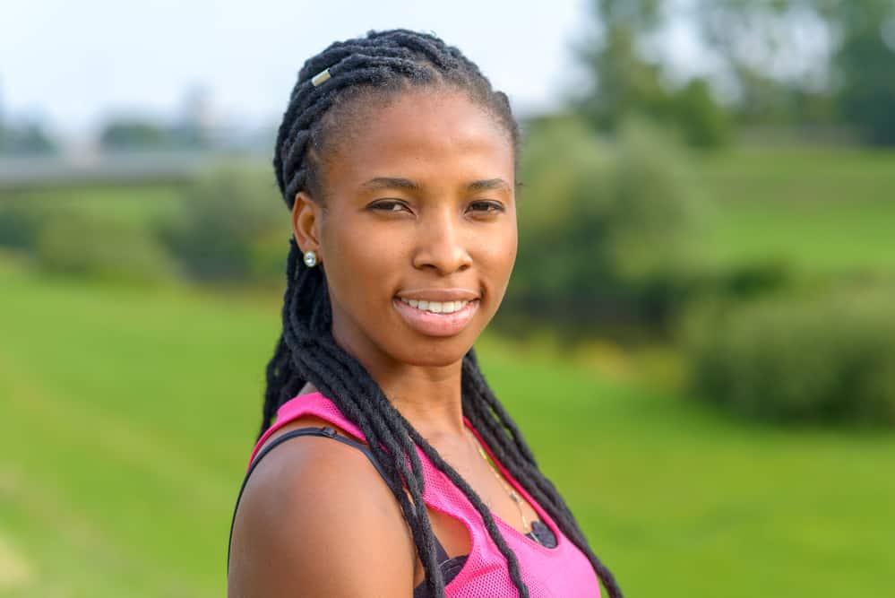 Young African American lady with dry hair and an itchy scalp due to all the dirt build up on her locks