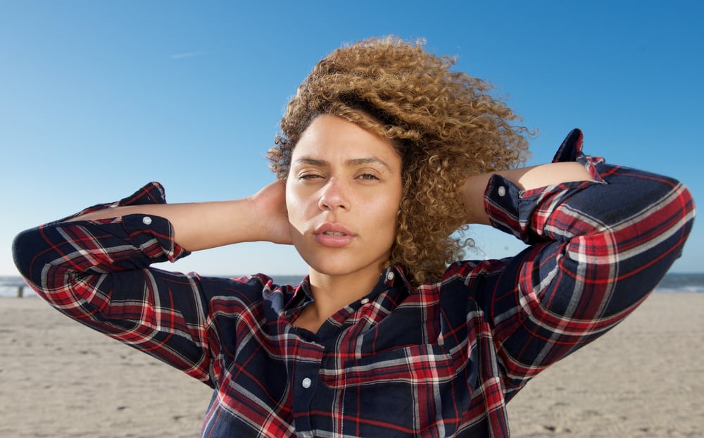 African American woman with beautiful curls after using blonde hair dye