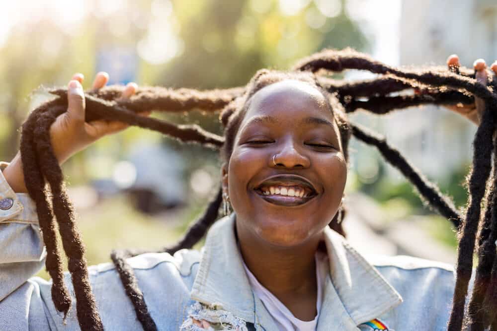 Cute black female wearing wick locs created with the crochet method allowing locs to merge together