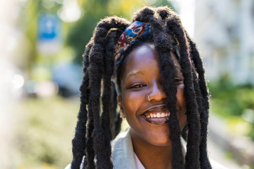 Black girl wearing wick locs that naturally form with existing dreadlocs in an infamous upright habit