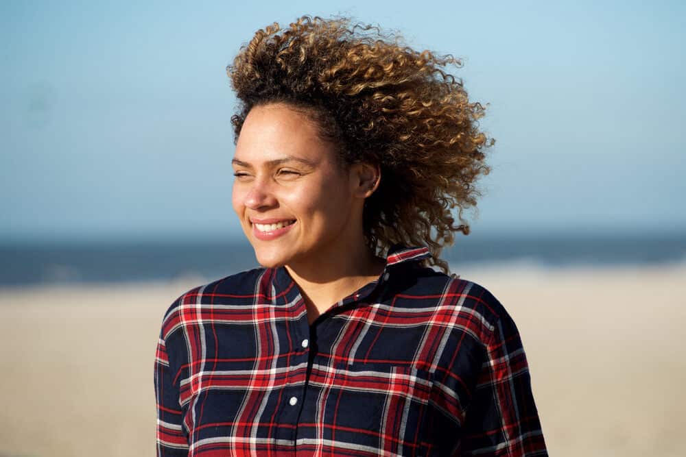 Black girl at the beach after leaving the hair salon with an ombre hair coloring treatment