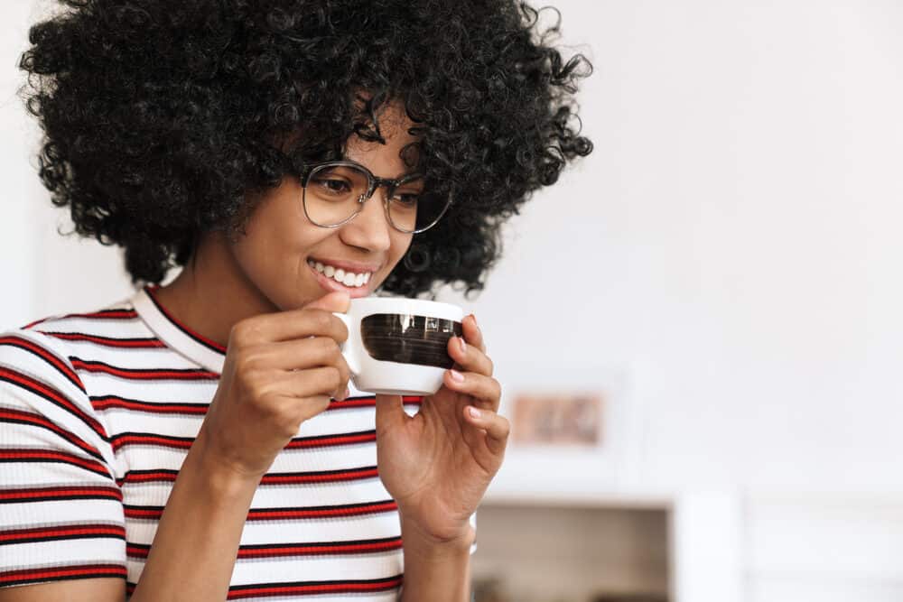 African American woman with curly hair wearing a red, white, and black shirt 