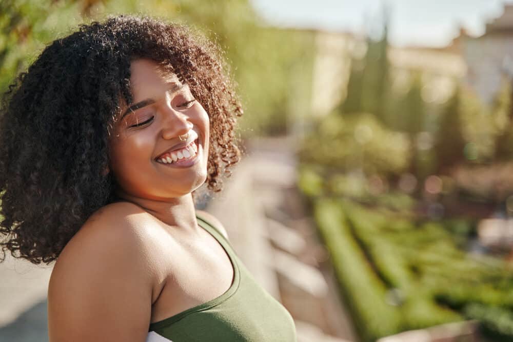 Cute black girl with caramel skin and a great smile posing for a photo outdoors