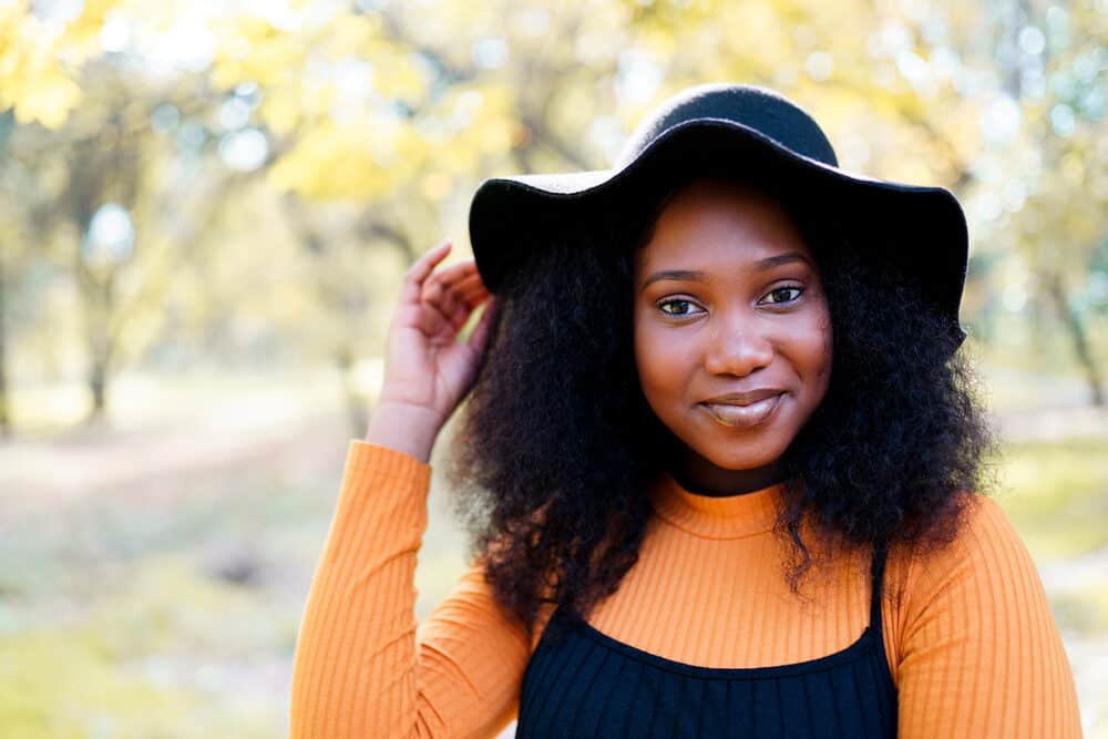 Black female with wavy hair with a soft and flexible quality styled with an oil-based pomade