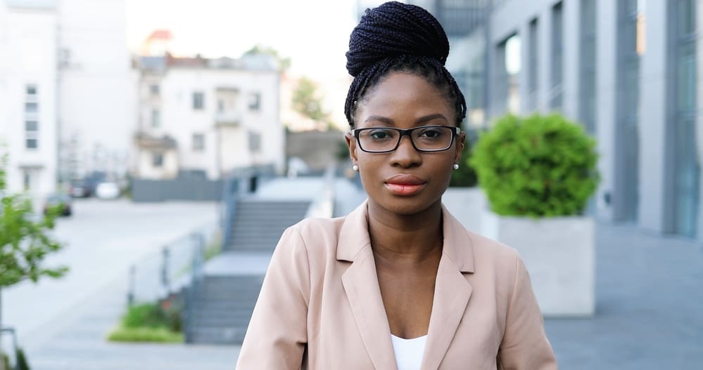 Tender headed black lady with goddess locs wearing eye glasses and business suit