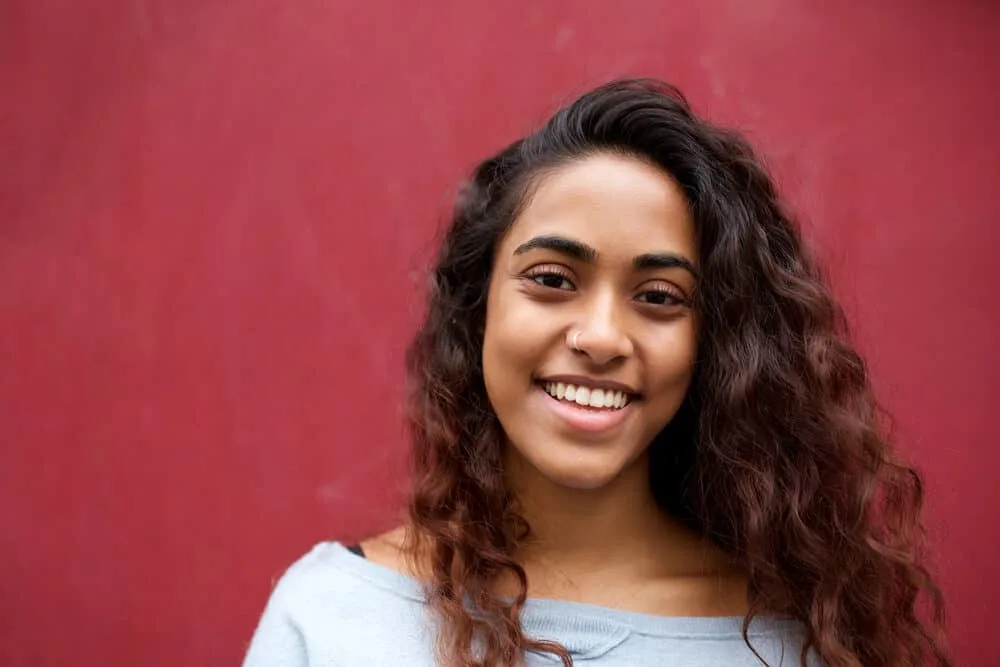 Learn How to Do Balayage on Black Hair at Home: Step-by-Step 2 Happy young Indian woman wearing subtle highlights with a caramel balayage