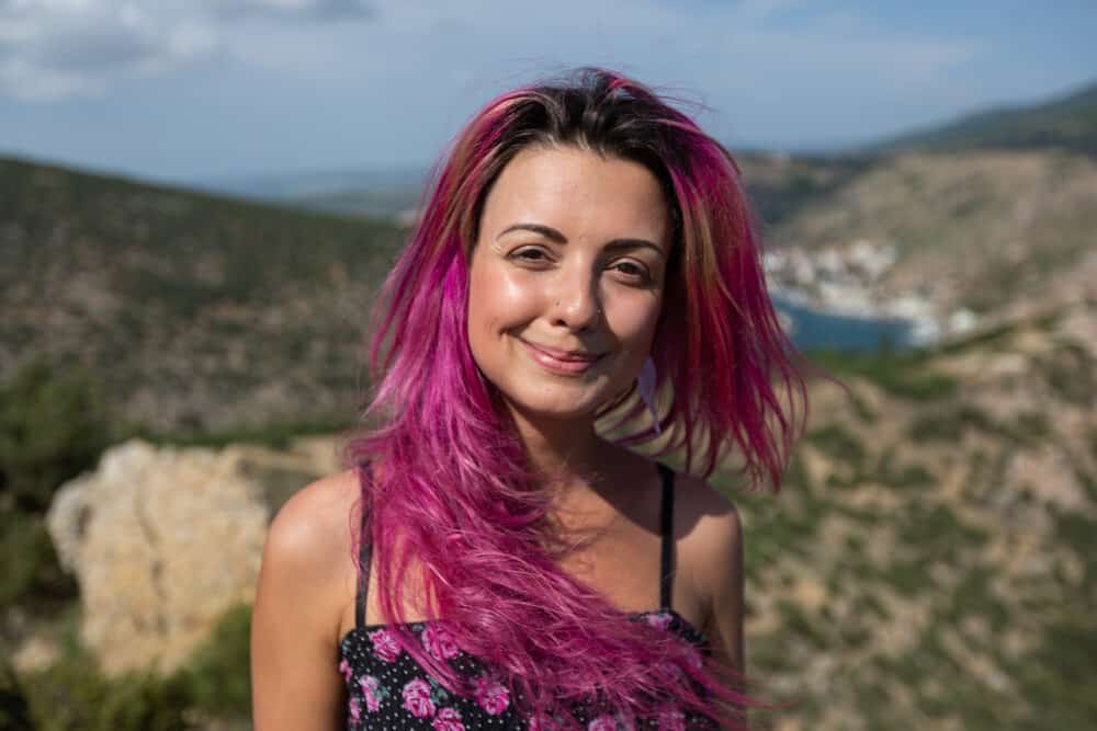 Cute girl with pinkish-purple hair covering her natural colour (color) with red hair dye