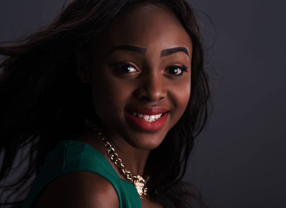 Stylish African American female wearing a wig with synthetic hair strands and natural fibers