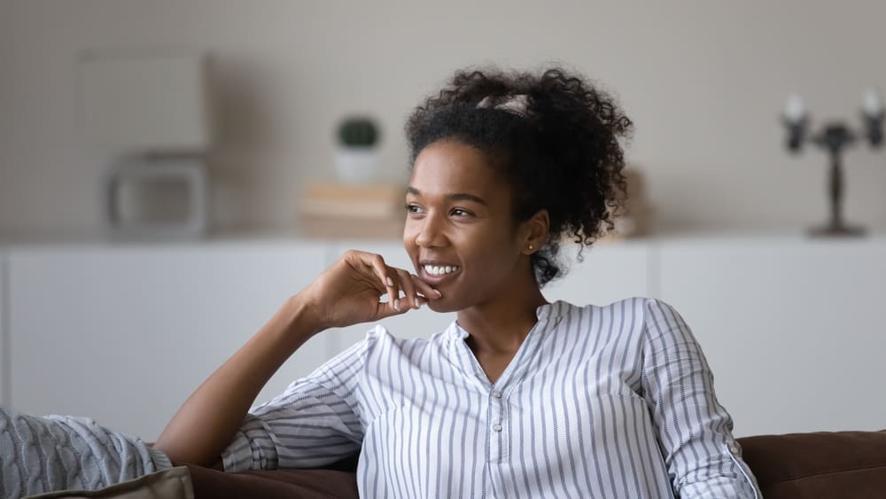 Happy African American lady with natural hair maintained without any harsh chemicals