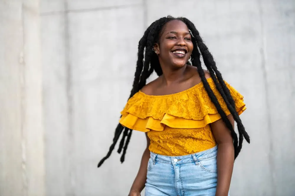 How Long Does It Take To Grow Dreads to Your Shoulders From Short Hair? 8 Lady wearing a yellow shirt and blue jeans with wick dreadlocks