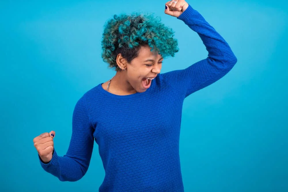 How to Dye Dark Hair Blue Without Bleaching It: DIY Guide 8 Black girl wearing a midnight blue sweater with electric blue hair dye in textured curly hair