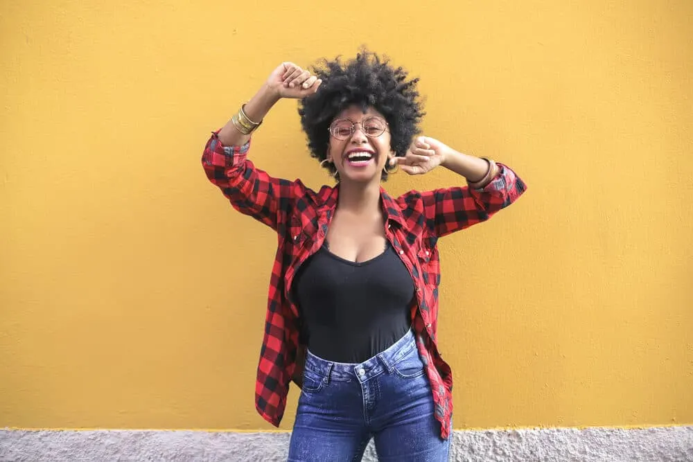 Drying Natural Hair Under a Hooded Dryer: Step-by-Step DIY Guide 7 Black girl dancing outside wearing casual clothes and fully dry frizz-free afro picked wash n go