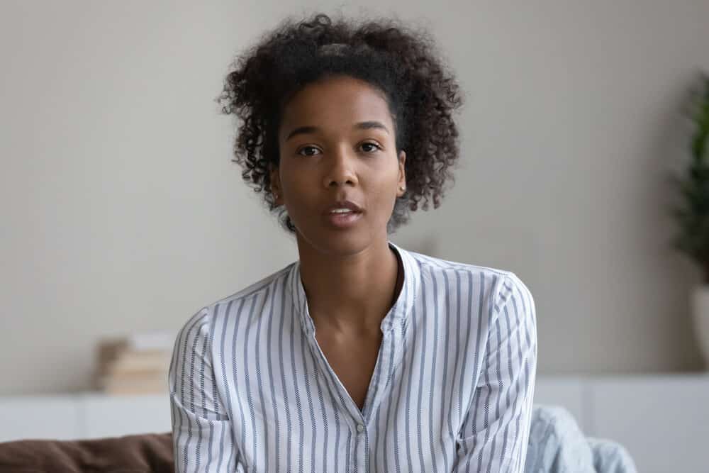 African American woman with oily hair strands looking wash her hair with one of Pantene's shampoos