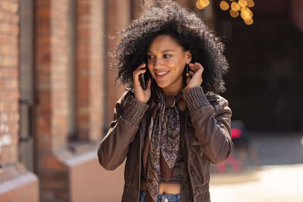 Young African lady with curly black hair styled with Herbal Essences Tousle Me Softly Mousse