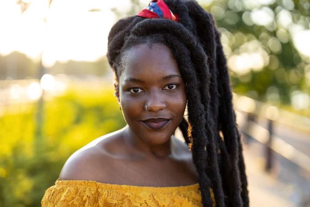 Black lady leaving the hair stylist with dreadlocked hair wearing a nose ring