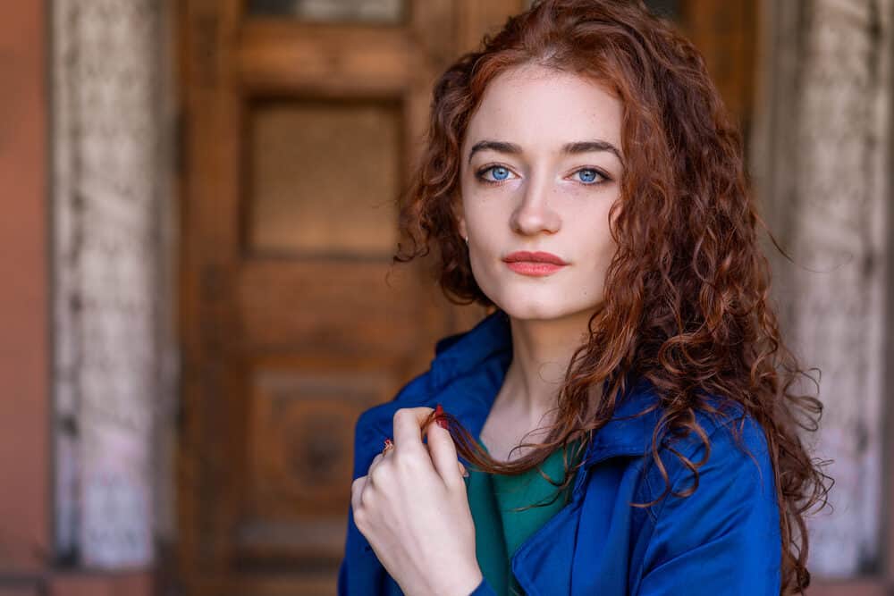 Beautiful woman with wavy red hair and blue eyes wearing Aspen Texture Molding for edge styling