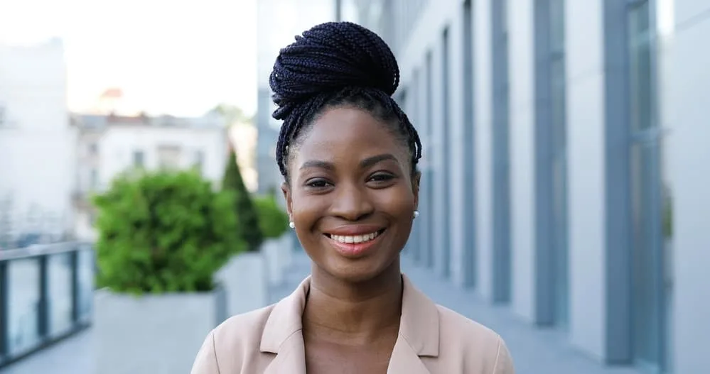 How To Relieve Tight Braids Causing Headaches, Pain, Bumps, and More 6 Pretty black lady wearing red lipstick and smaller braids in an updo style