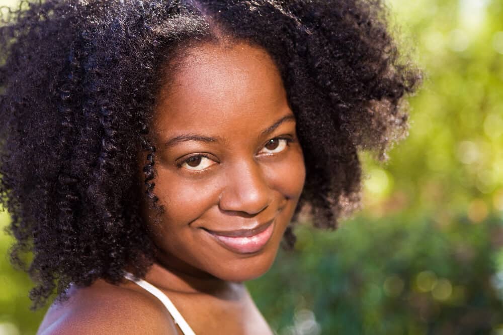 Mature black lady with a great smile with shiny strands treated with warm olive oil