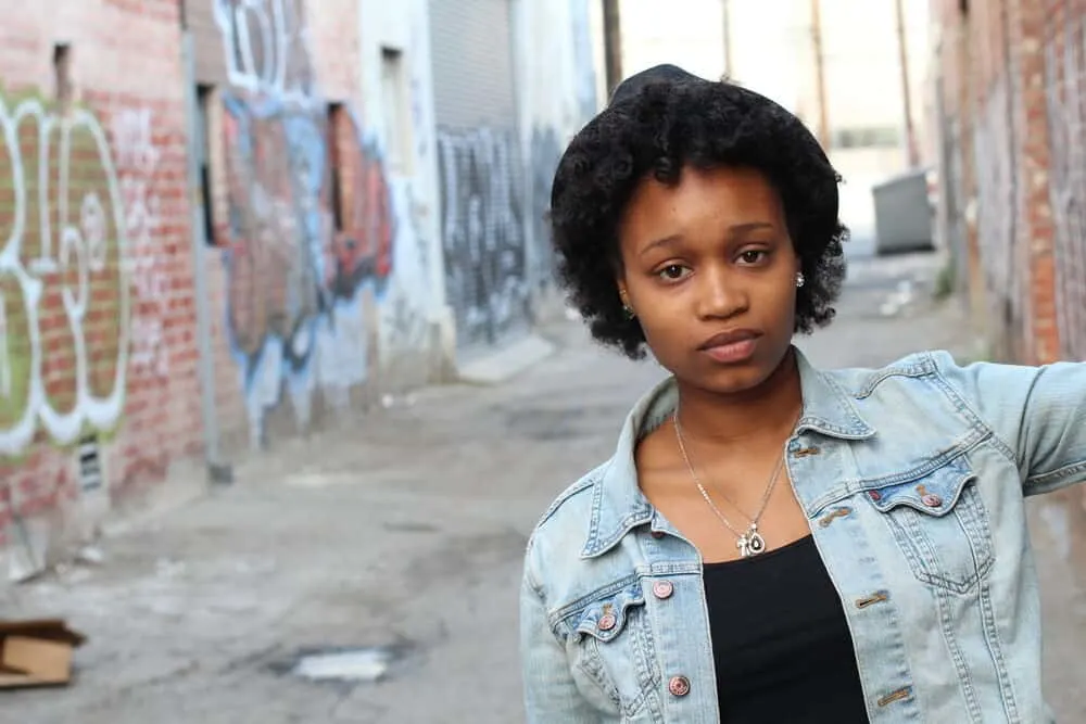 Pretty young black female with afro hair wearing a jean jacket