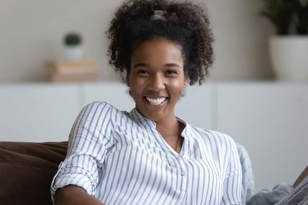 Millennial black girl with a great smile and curls that appear to be 4a and 4b hair types