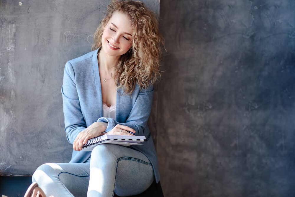 Lady with castor-oil hair treatment wearing a sports coat and blue jeans 