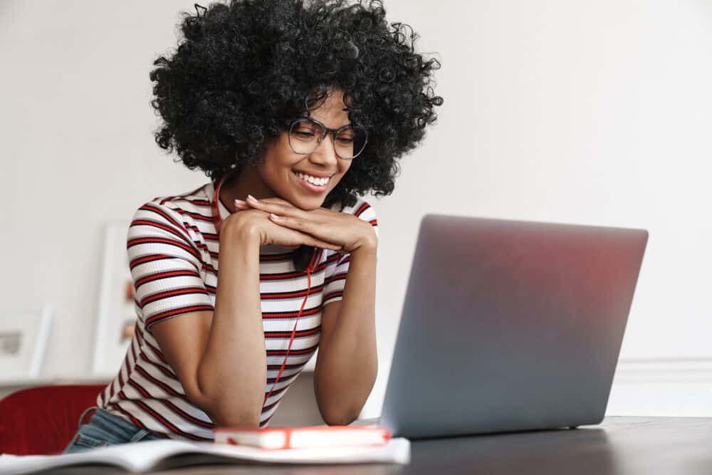 African American student with curly natural hair dried using a soft bonnet dryer