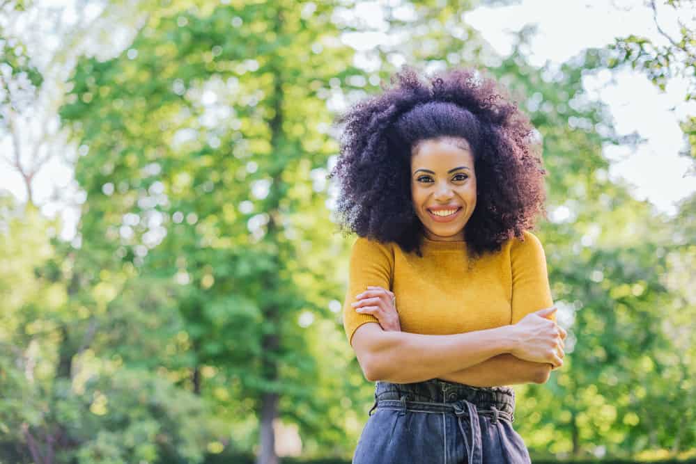 Black female wearing casual clothes with naturally curly hair