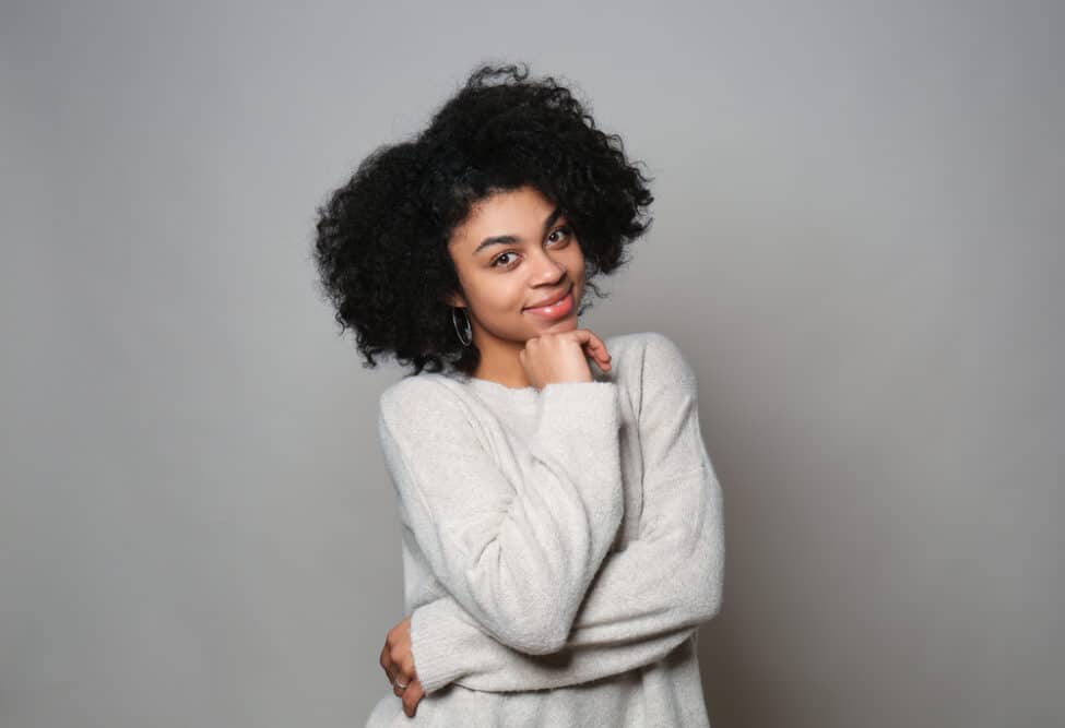 Female with type 4A natural hair type wearing a fuzzy sweater looking directly into the camera.