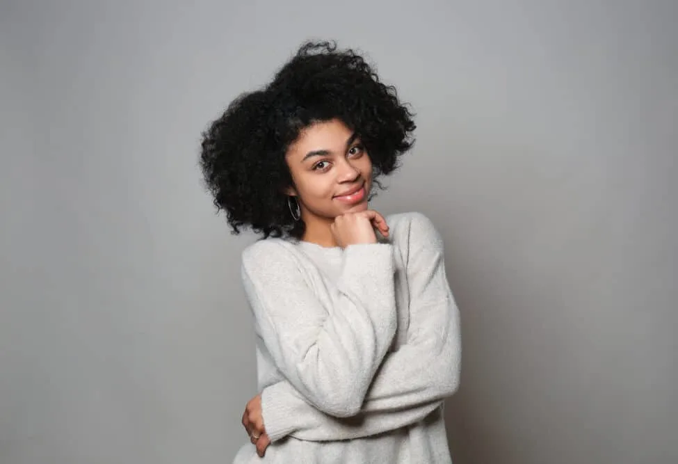 Do Hair Products Expire? Can You Use Expired Hair Products? 7 Female with type 4A natural hair type wearing a fuzzy sweater looking directly into the camera.