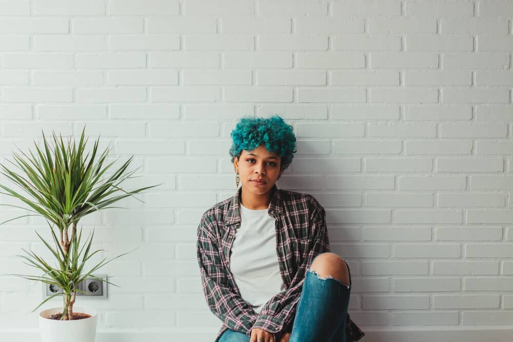 Young mixed-race girl with naturally light brown hair wearing a casual plaid shirt and blue jeans