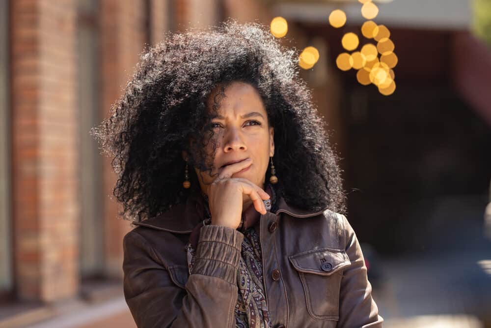 Light-skinned black girl biting her finger naturally curly human hair