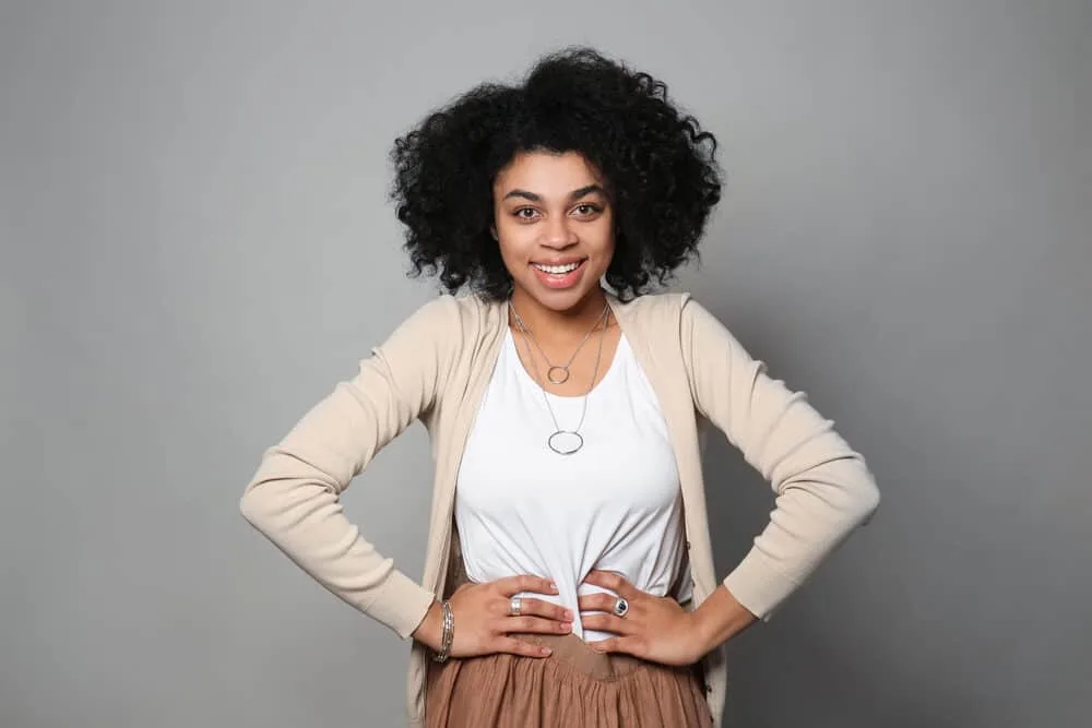 Do Hair Products Expire? Can You Use Expired Hair Products? 5 Black women with naturally curly hair wearing a light brown sweater, white shirt, brown skirt, and a ring necklace.