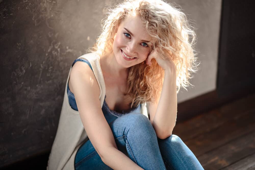 Caucasian female with wavy hair and blue eyes following DIY natural hair castor oil treatment