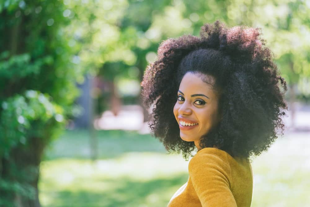 Cute black girl with coily hair strands styled with virgin coconut oil