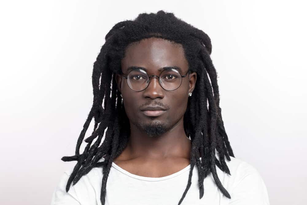 Black man wearing loc extensions with synthetic hair from the beauty supply store