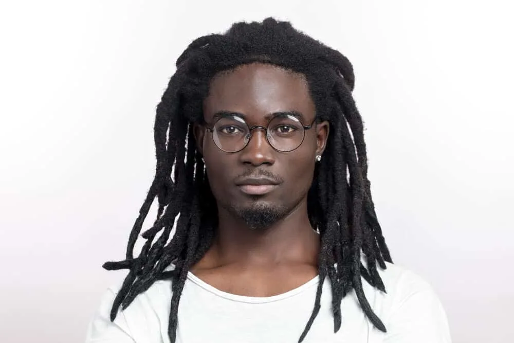 Black man wearing loc extensions with synthetic hair from the beauty supply store