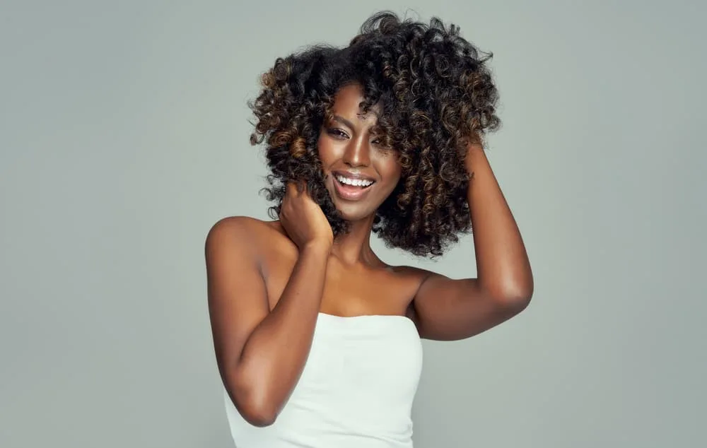 Hair Webbing: What Is It, Causes, and How to Fix Your Hair 7 Cheerful black girl brown and black curls following the Curly Girl Method