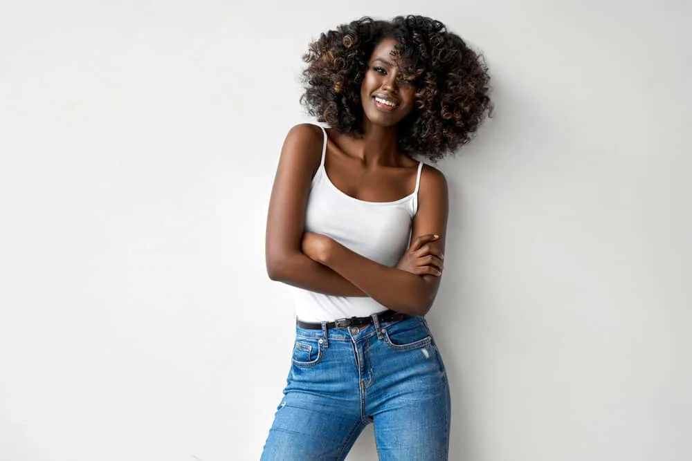 Hair Webbing: What Is It, Causes, and How to Fix Your Hair 2 Black girl with curly flat twist styled with Shea Moisture leave-in conditioner wearing a white tank top and blue jeans