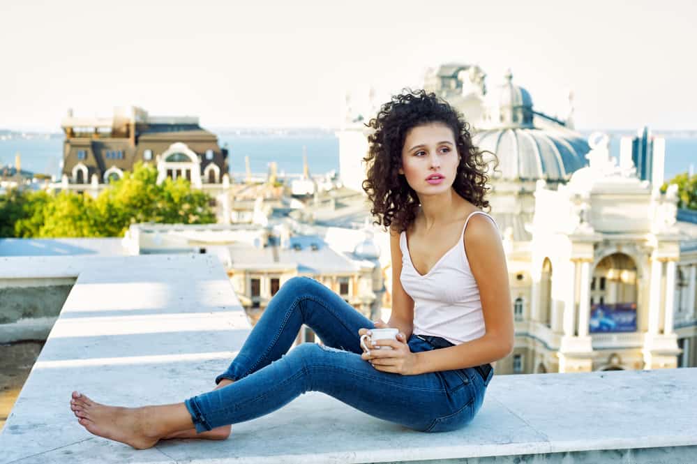 Cute white girl wearing make-up and drinking coffee on the roof