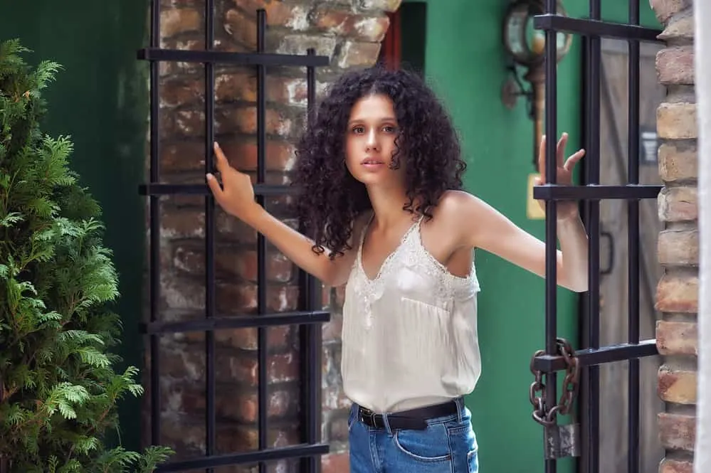 Can a White Person Use a Hair Relaxer? What Happens? What Does It Do? 2 Petty white girl with brown natural hair standing outside between an open gate