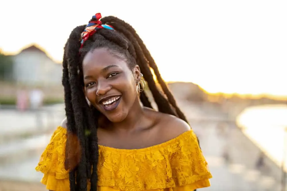 How Long Does It Take To Grow Dreads to Your Shoulders From Short Hair? 2 Lady with African hair wearing hoop earrings and dark red lipstick