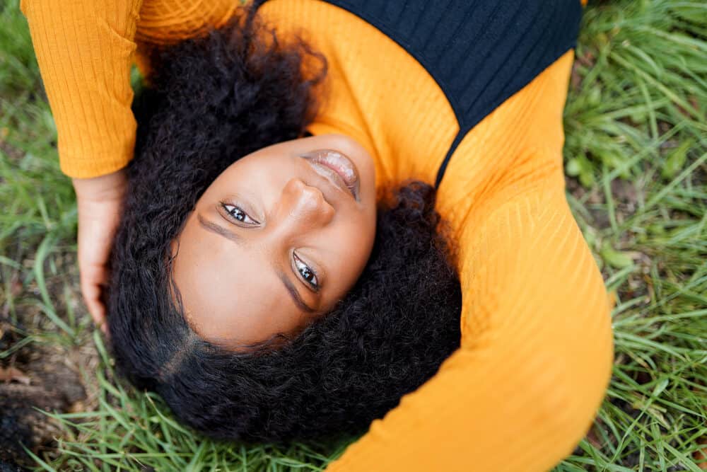 Black girl with hair gel on top of her head giving her curls a shiny appearance 