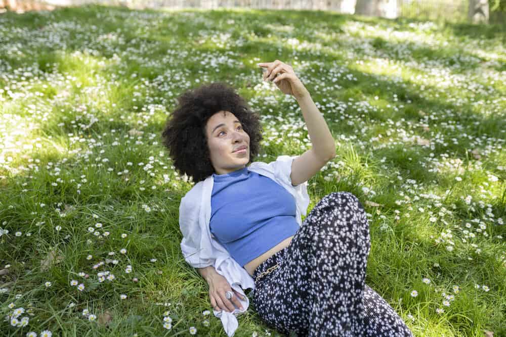 Black lady wearing casual clothes with super curly natural hair 