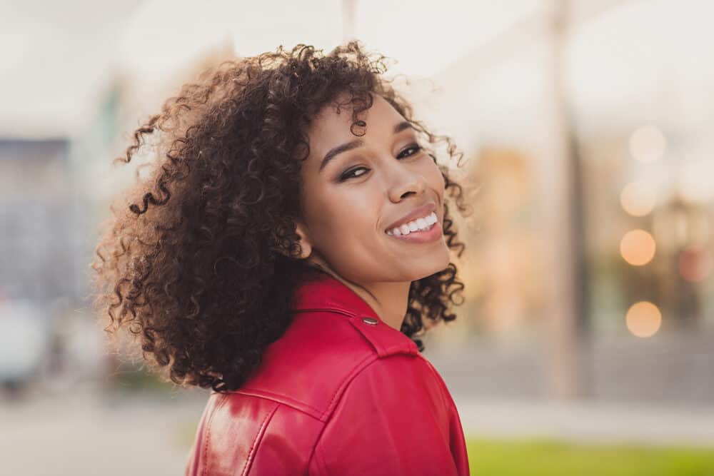 Black girl with natural 4A curls wearing brown semi-permanent hair color.