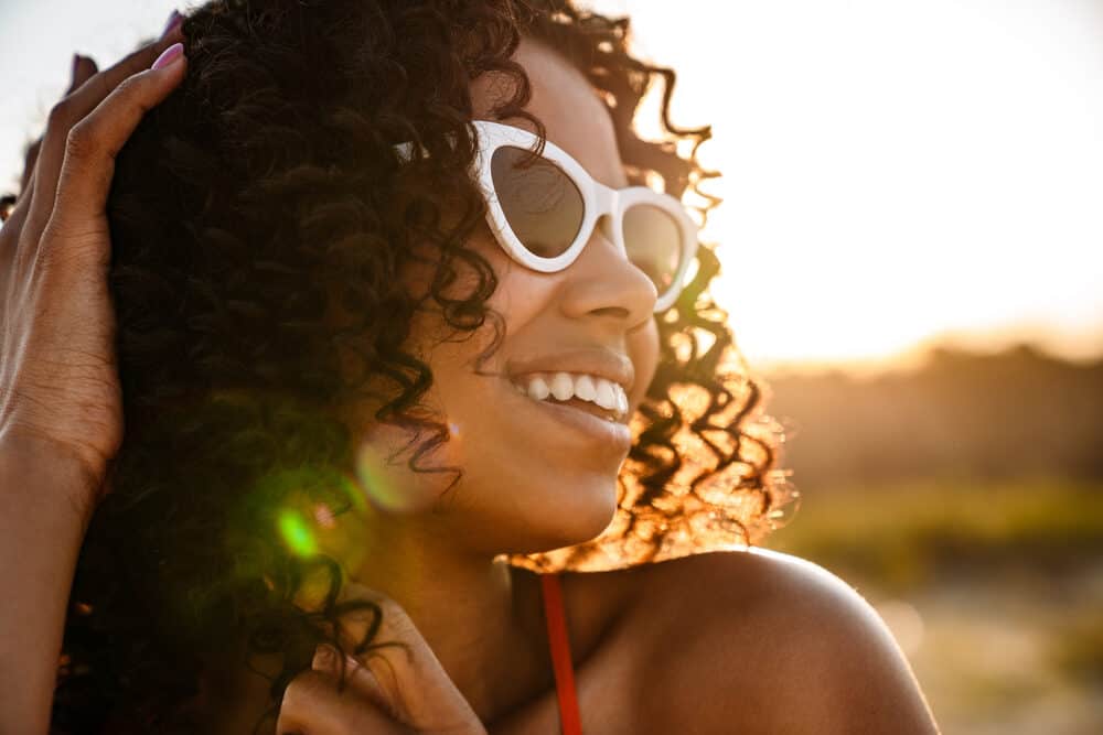 Beautiful young female with bouncy 4A curls styled with our Cantu shea butter and vegan styling products.