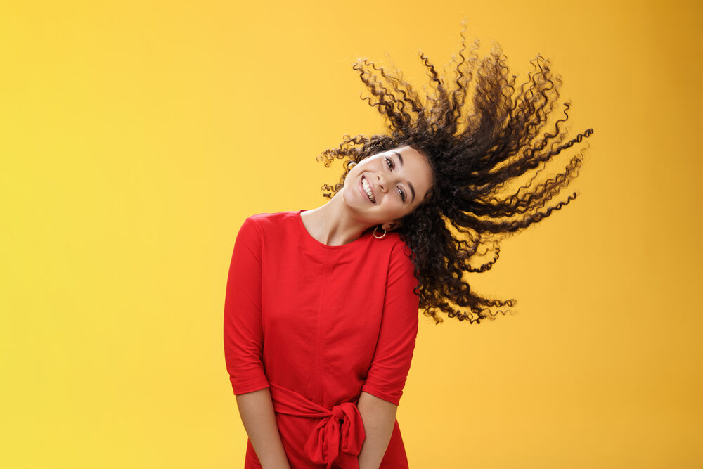 A lady with freshly permed hair allow her curls to air dry after washing her hair with warm water.