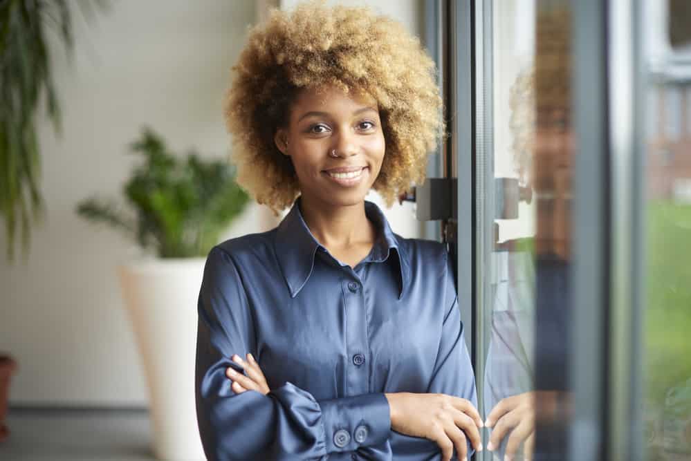Does Bleaching Your Hair Damage It Forever? Repair Hair After Bleaching 3 Cute African American female with blonde healthy hair without any signs of bleaching damage or split-ends.