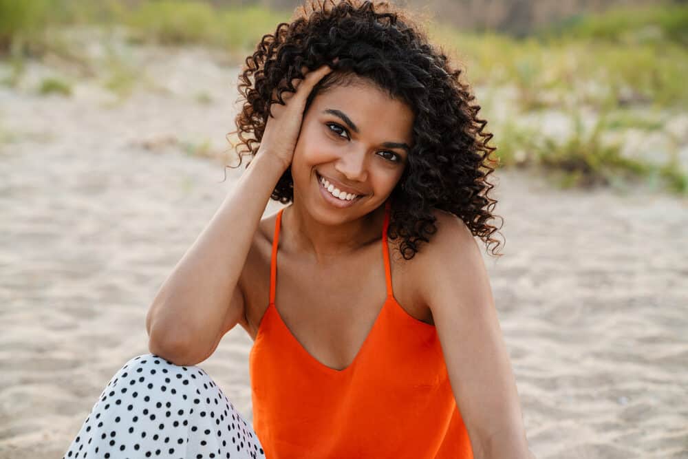 Young African woman with spiraling curls created with cruelty-free essential oils and vegan hair moisturizer.