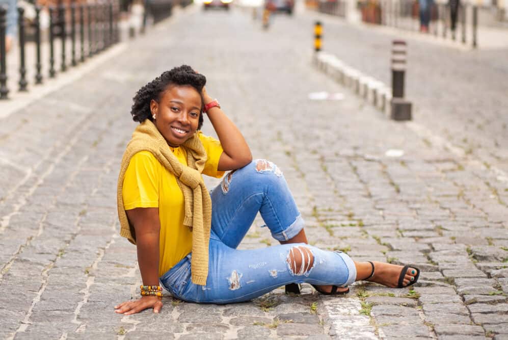 Lady wearing casual clothes including torn jeans with 4B healthy hair strands.