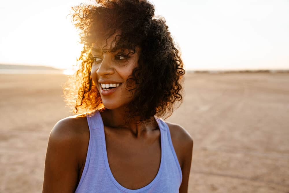 Young black girl with curly hair styled with reddish-brown hair coloring products.